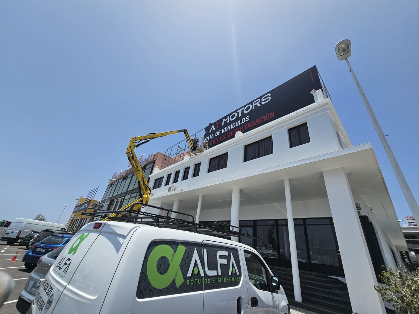 Equipo de ALFA instalando un rótulo con grúa y furgoneta propia
